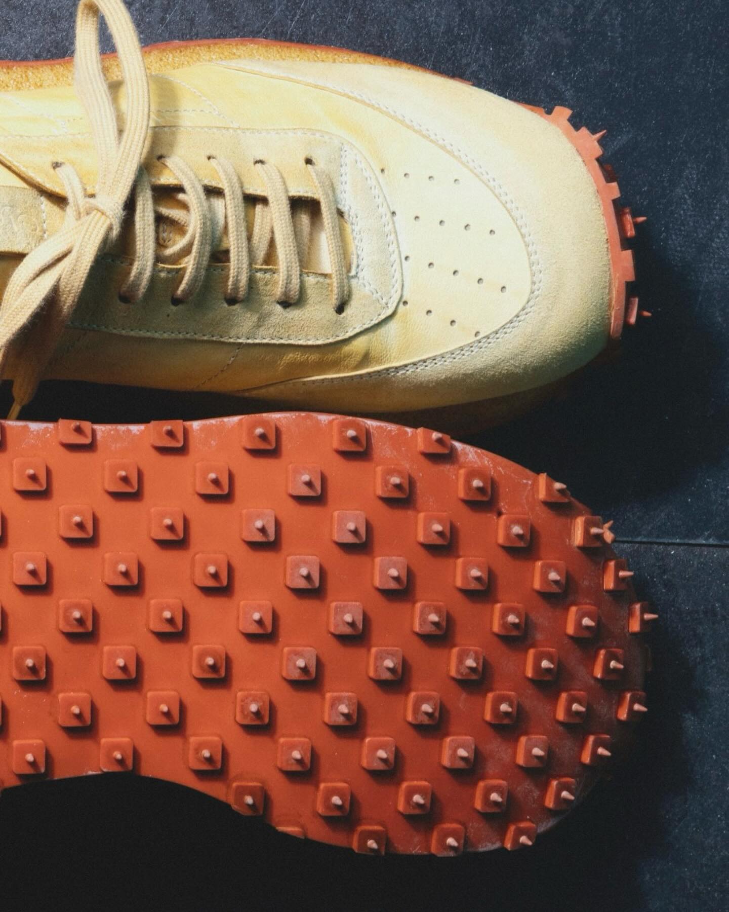 Shoto cream sneaker with orange studded outsole detail