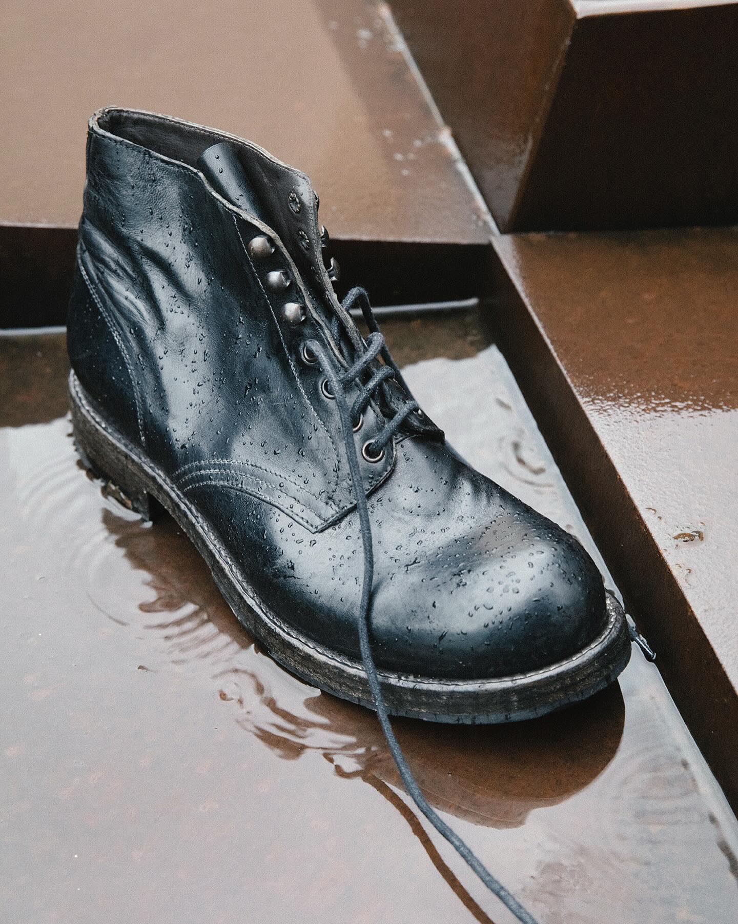 Shoto black lace-up boot photographed on wet metal steps